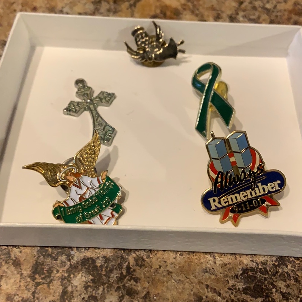 Assorted pins, a couple 911 Remembers , a cross pendant (no chain)